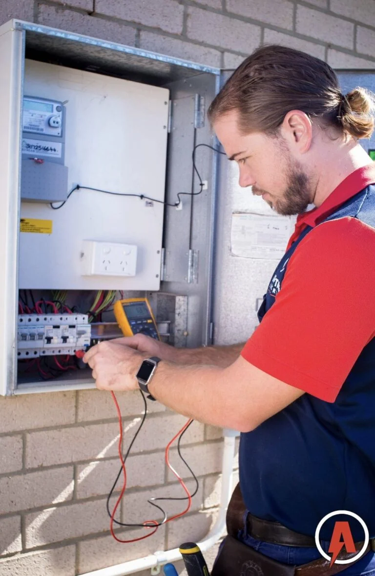 Armitage Electrical electrician testing a switchboard with a multimeter