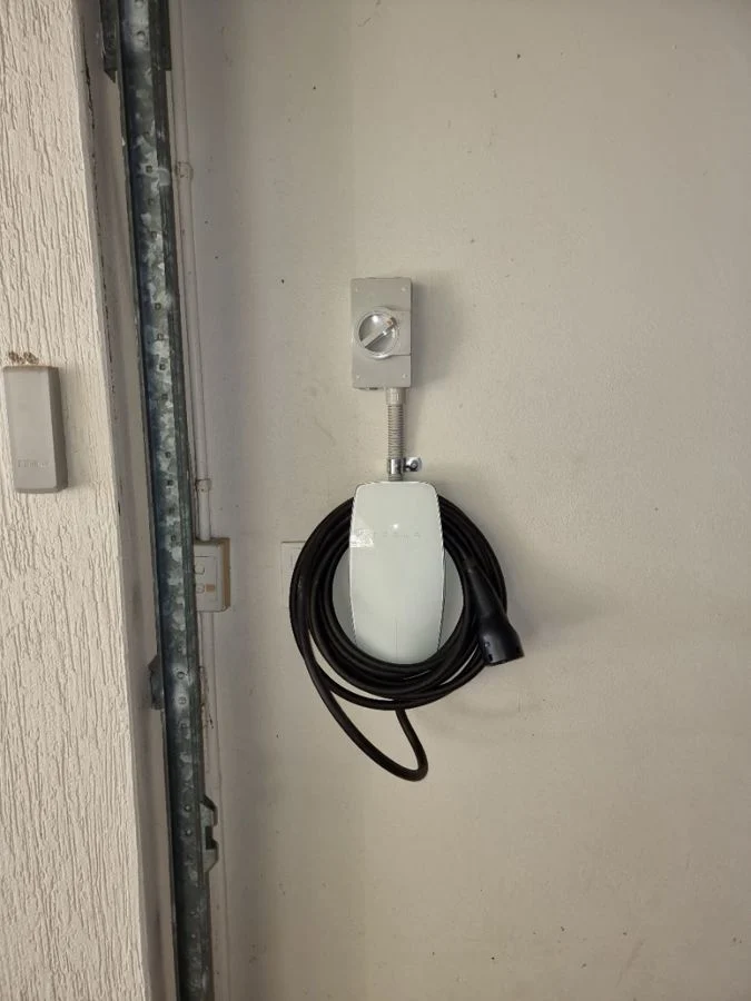 Tesla Wall Connector with isolator installed in a garage by Armitage Electrical